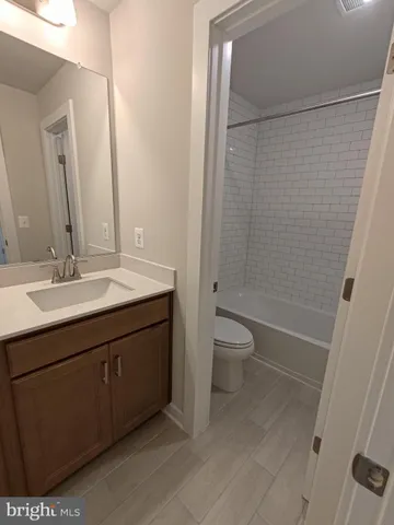 a white toilet and tub sitting next to a bathroom sink