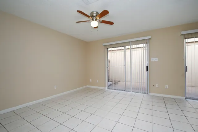 a view of an empty room and window ceiling fan