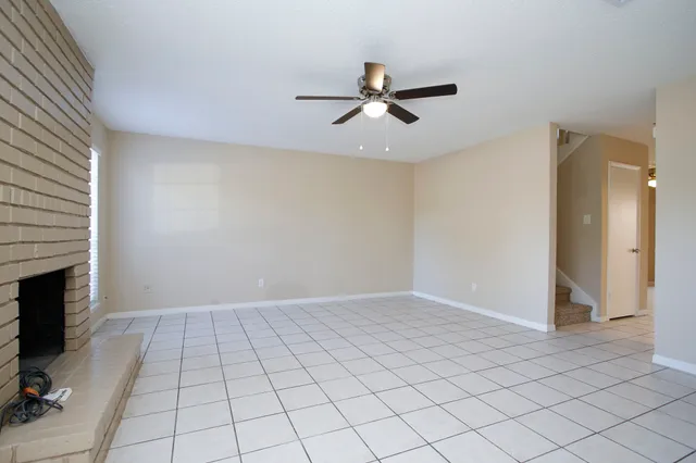 an empty room with windows and fireplace