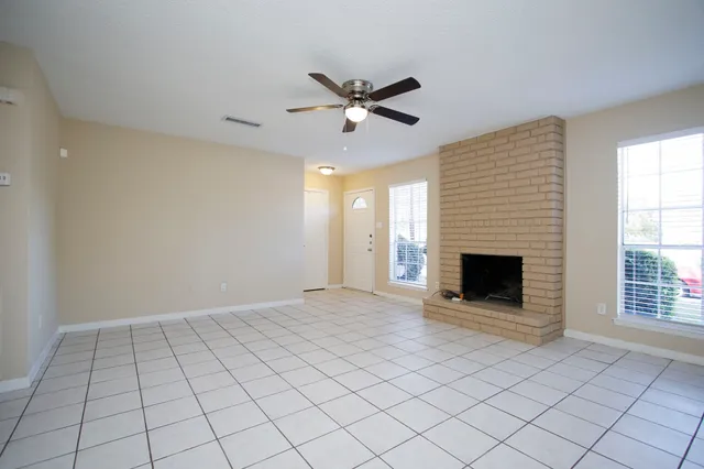 a view of an empty room with a fireplace and a window