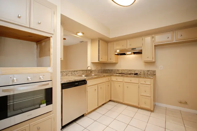 a kitchen with stainless steel appliances granite countertop a stove and white cabinets