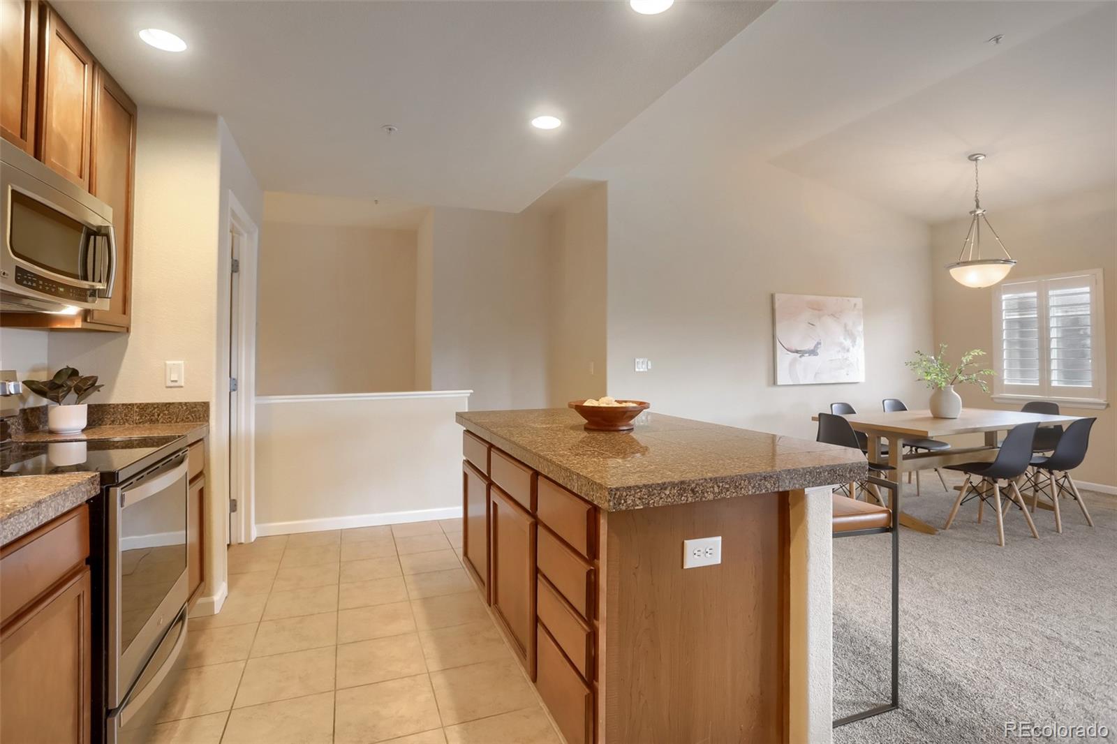 6232 Kilmer Loop, Unit 203 Golden, CO 80403 - Photo 16 of 33 a kitchen with stainless steel appliances granite countertop a stove a sink and a refrigerator