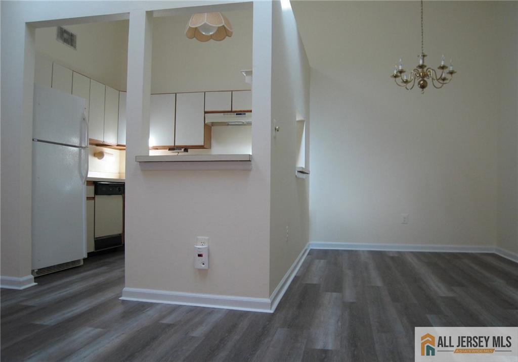 152 Darwin Lane North Brunswick, NJ 08902 - Photo 13 of 14 a view of kitchen and empty room with wooden floor