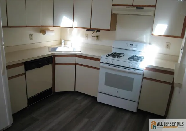 a kitchen with a stove cabinets and wooden floor