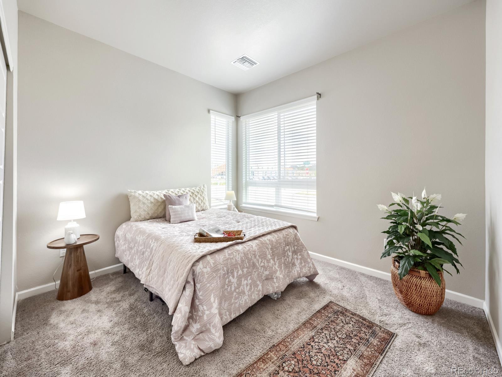 6153 North Ceylon Street, Unit 10108 Denver, CO 80249 - Photo 7 of 11 a bedroom with a bed and a potted plant