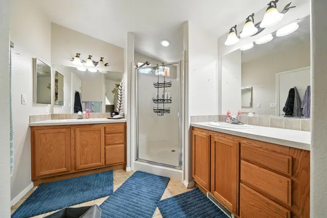 a spacious bathroom with a granite countertop sink a mirror and a shower