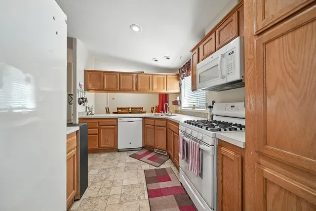 a kitchen with stainless steel appliances granite countertop a stove a sink and a refrigerator