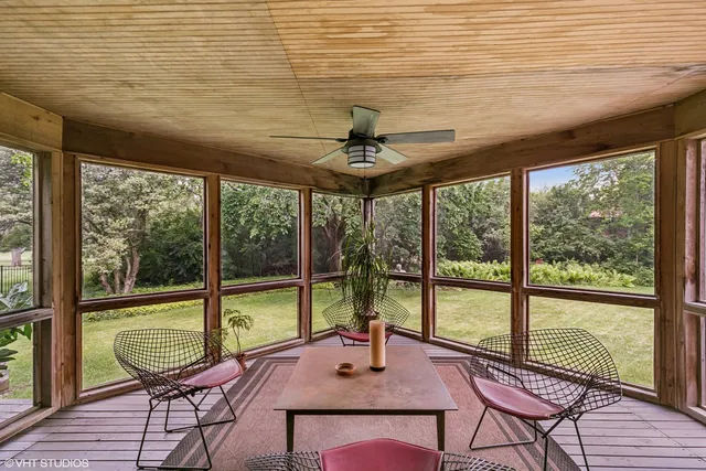 a view of a hallway with wooden floor and a bathroom