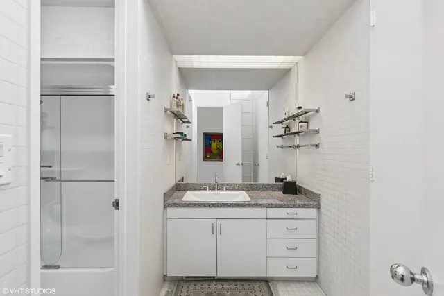 a bathroom with a granite countertop sink a toilet and a mirror