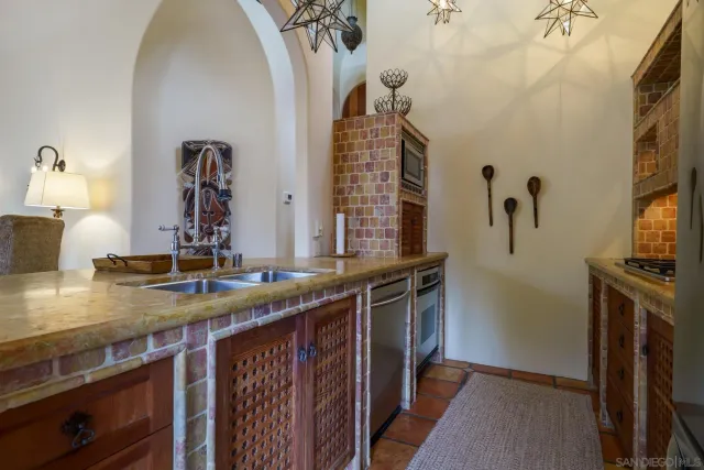 a kitchen with sink a stove and wooden floor