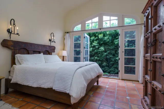 a bed sitting in a bedroom next to a window