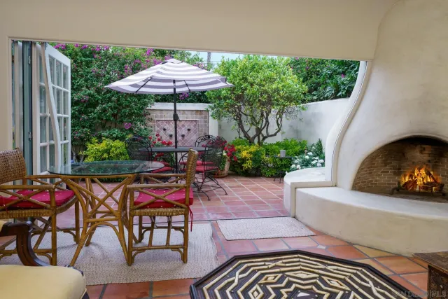 a view of a patio with furniture and table under an umbrella