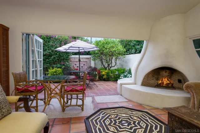 a view of a patio with a table and chairs under an umbrella