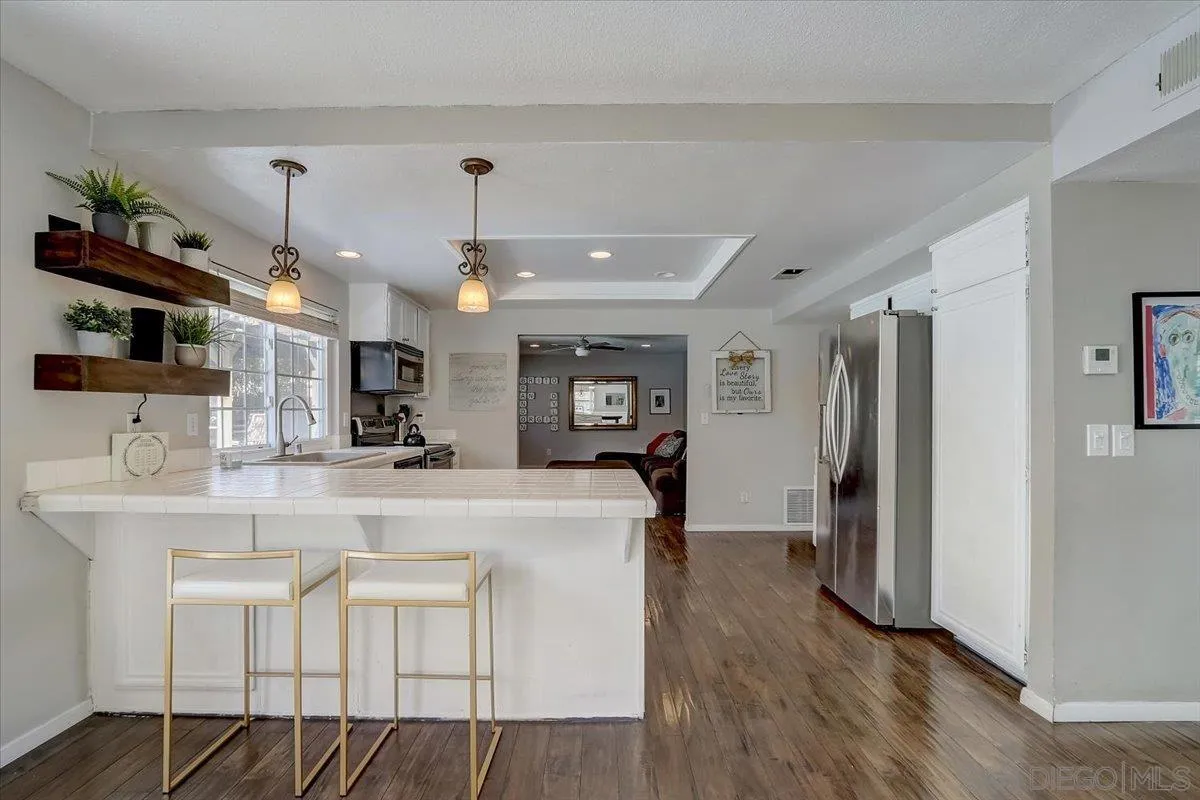 4094 Tambor Road San Diego, CA 92124 - Photo 16 of 49 a view of a kitchen with kitchen island a chandelier and refrigerator