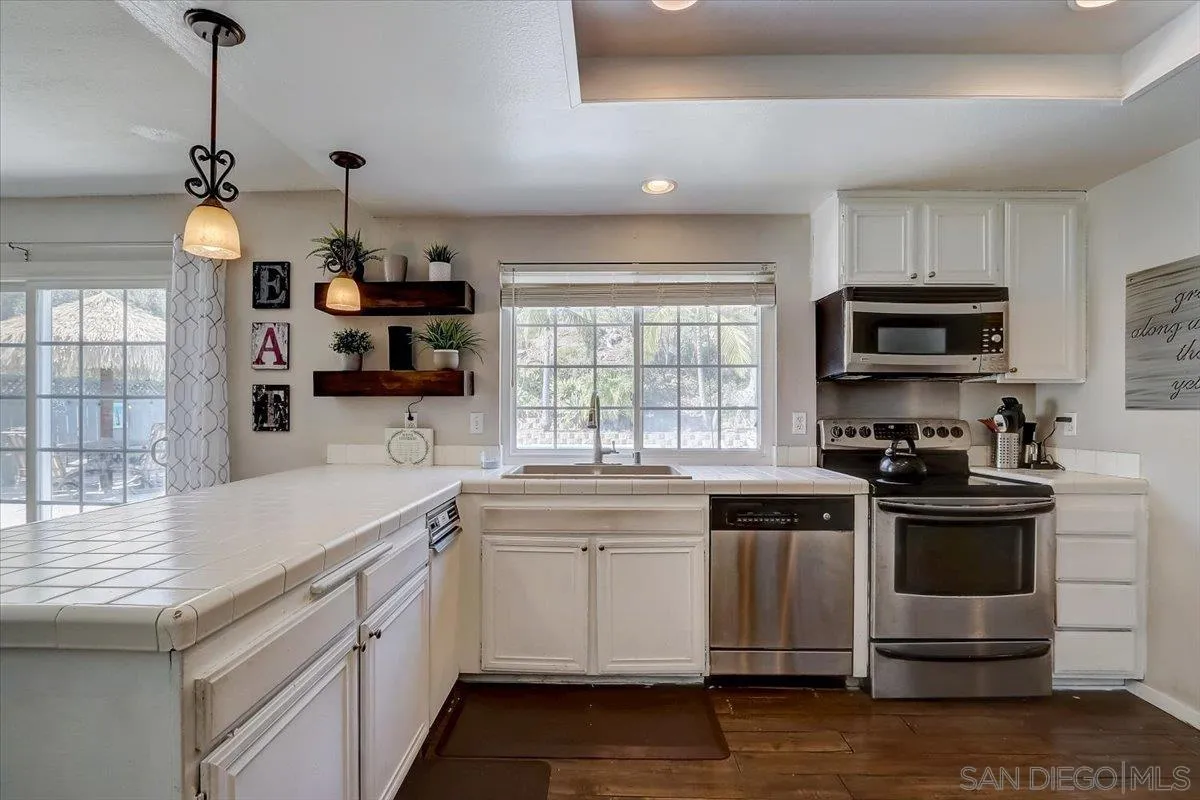 4094 Tambor Road San Diego, CA 92124 - Photo 17 of 49 a kitchen with a sink stove and microwave