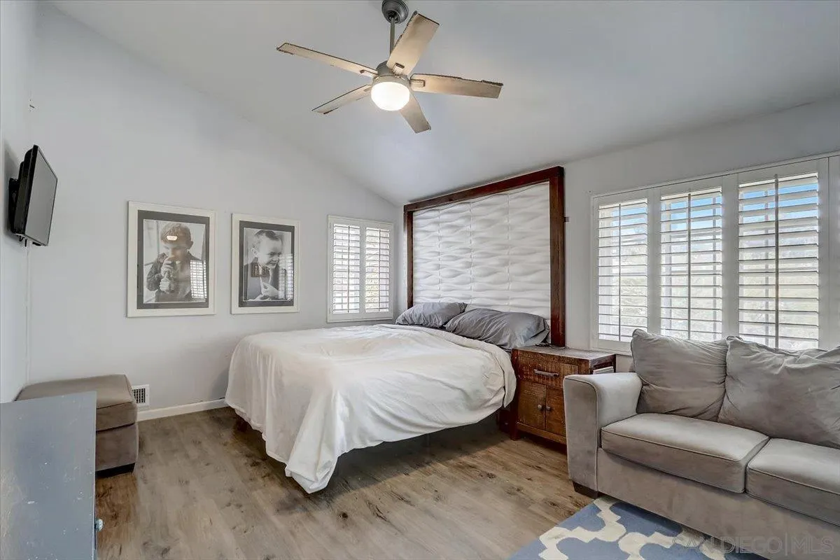 4094 Tambor Road San Diego, CA 92124 - Photo 25 of 49 a spacious bedroom with a large bed couch and a window