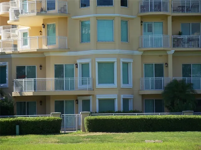 a front view of residential building with yard and large trees