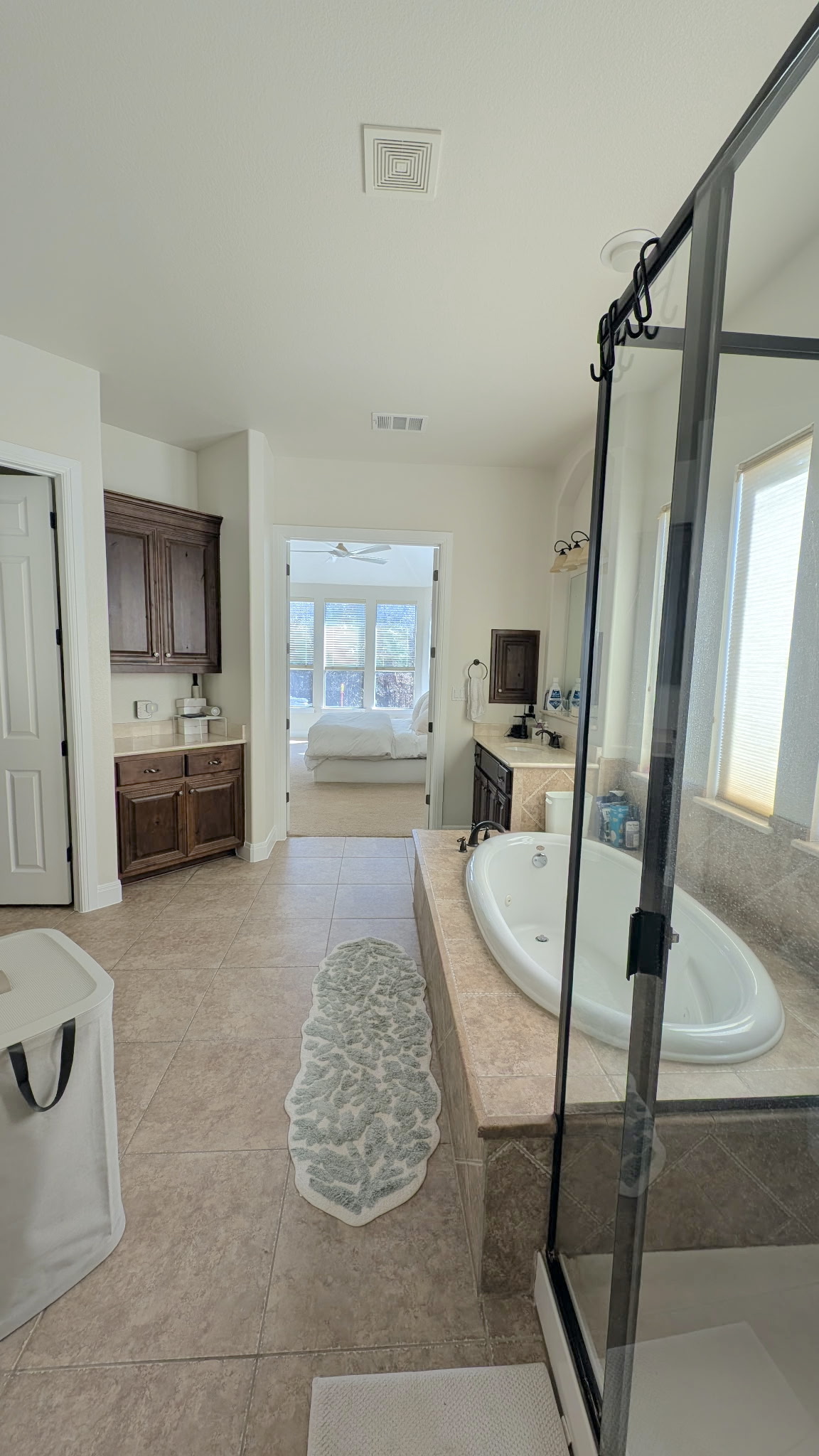 4205 Vail Divide Bee Cave, TX 78738 - Photo 14 of 28 Ensuite bathroom featuring a bath, vanity, a stall shower, and light tile patterned floors