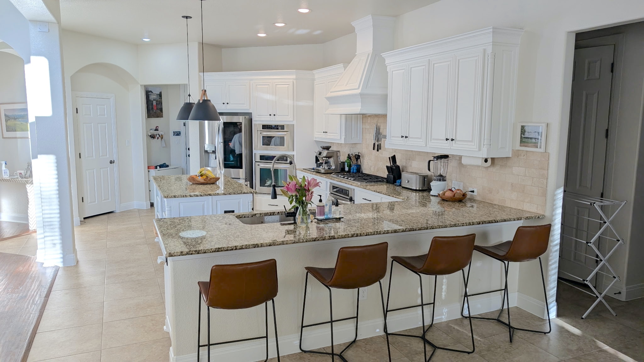4205 Vail Divide Bee Cave, TX 78738 - Photo 6 of 28 Kitchen with a granite island, white cabinetry, a breakfast bar and stainless steel appliances