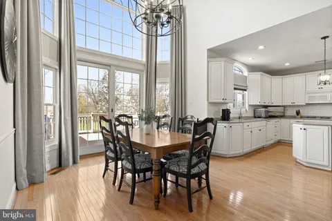 a dining room with furniture a chandelier and kitchen view