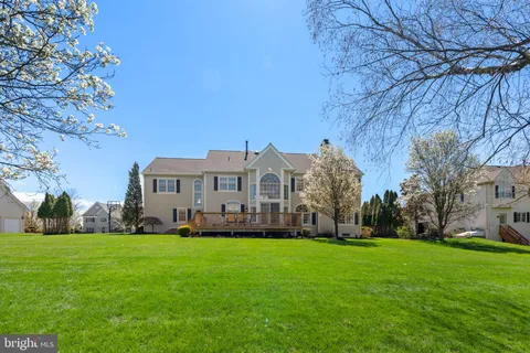 a view of a house with a big yard and large trees