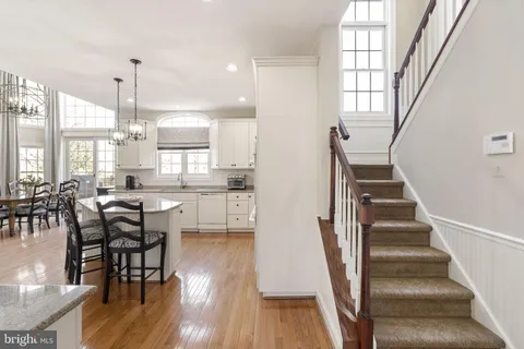 an open kitchen with wooden floor and stainless steel appliances