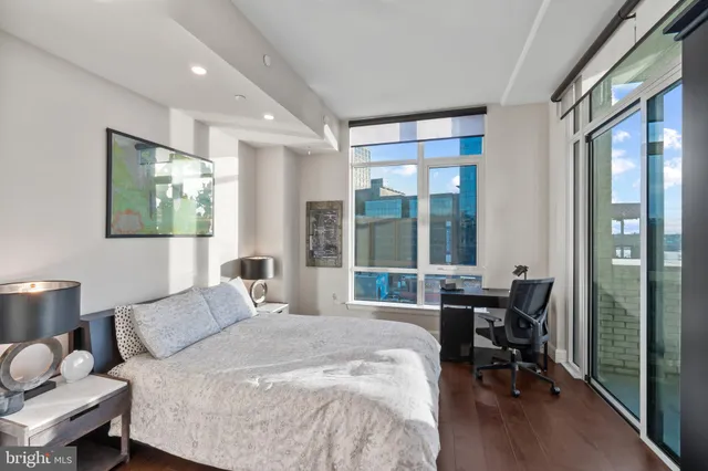 a bedroom with a bed and a large window