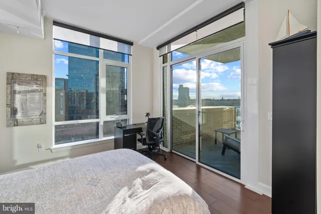 a bedroom with a large window and a glass door