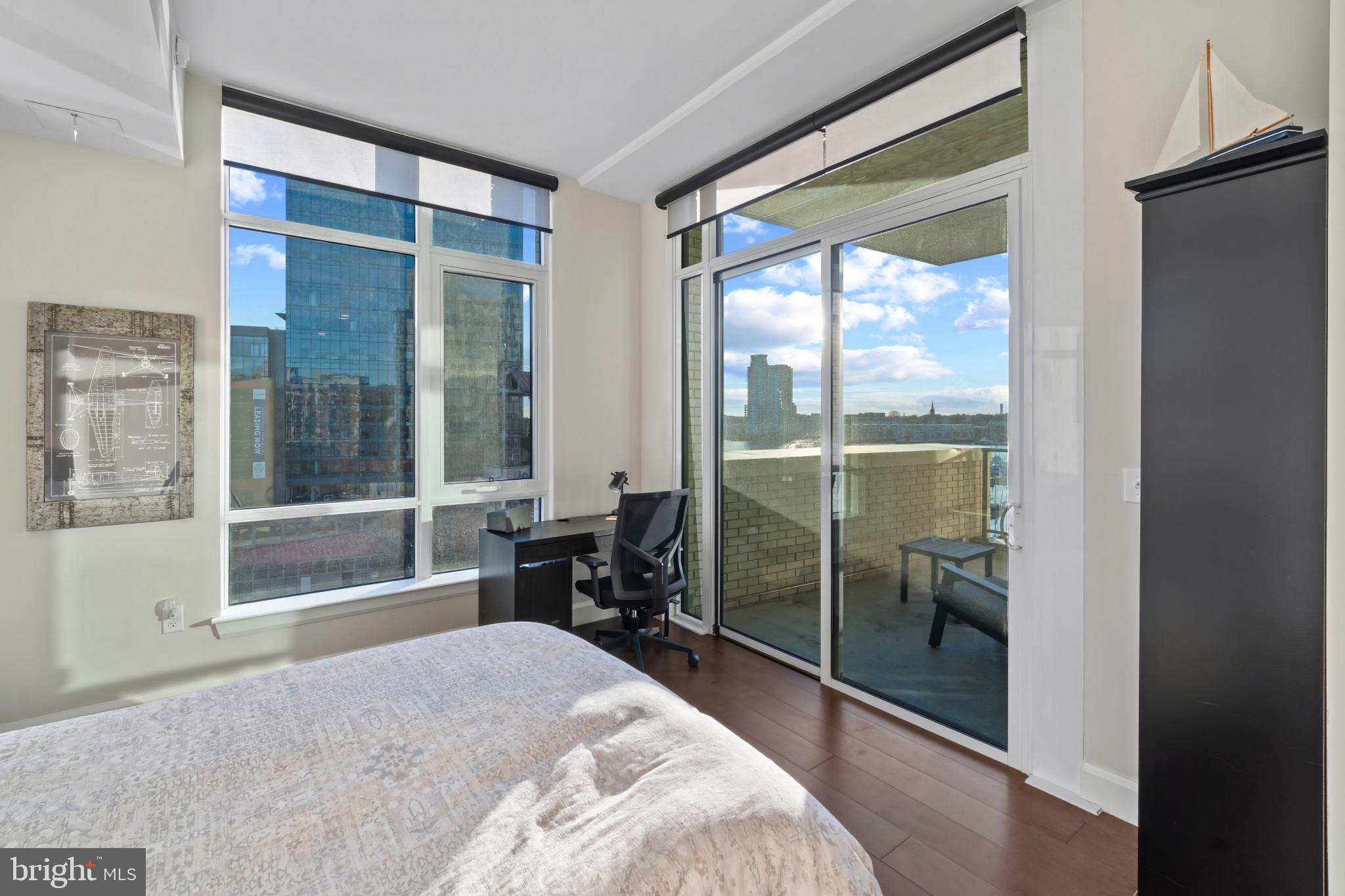 1330 Lancaster Street, Unit C602 Baltimore, MD 21231 - Photo 17 of 28 a bedroom with a large window and a glass door