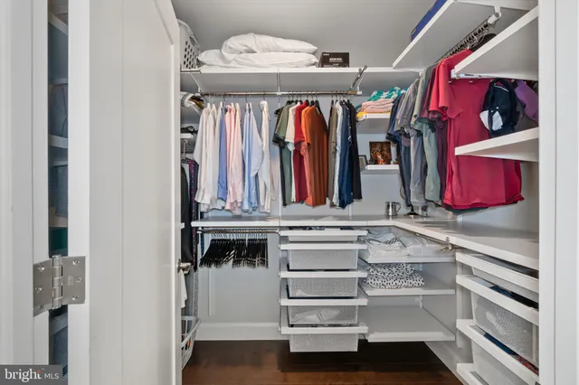 a view of walk in closet with clothes and shoes