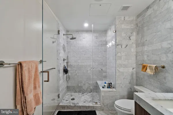 a bathroom with a granite countertop toilet sink and shower