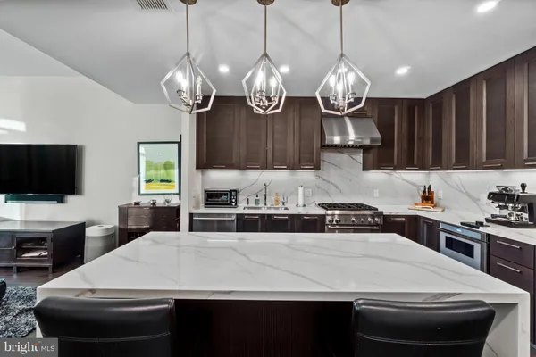 a kitchen with kitchen island granite countertop a sink a stove and cabinets