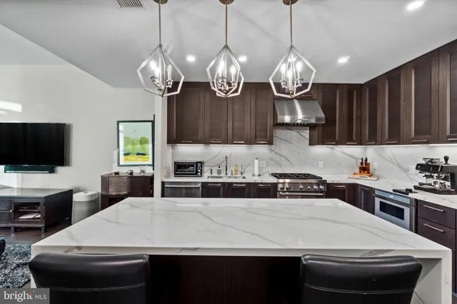a kitchen with kitchen island granite countertop a sink a stove and cabinets