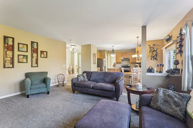 a kitchen with stainless steel appliances granite countertop a refrigerator a sink dishwasher a stove and white cabinets with wooden floor