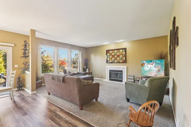 a kitchen with stainless steel appliances granite countertop a stove top oven a sink dishwasher a dining table and chairs with wooden floor