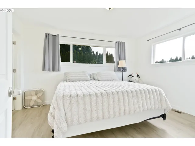 a large bed sitting in a bedroom next to a window