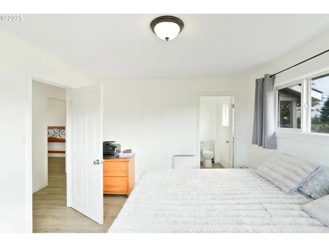 a bedroom with a bed cabinets and a window