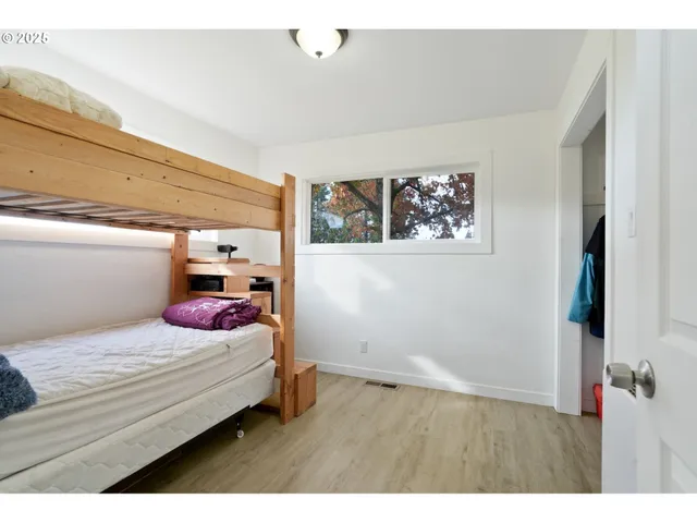 a bedroom with a bed and a painting on the wall