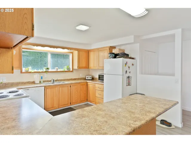 a kitchen with granite countertop a refrigerator stove top oven and sink