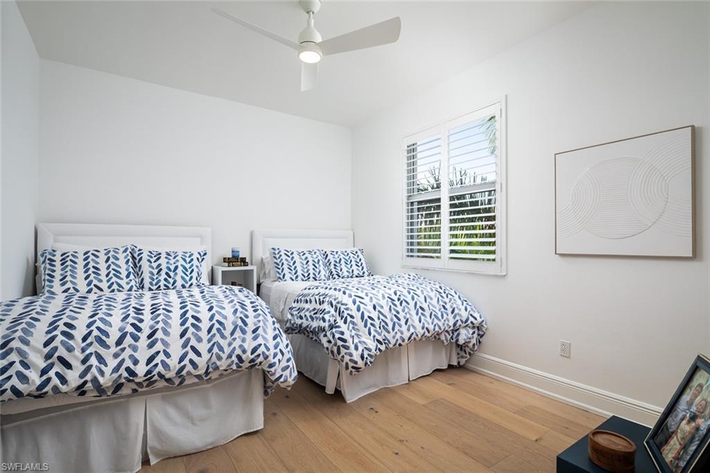 470 Launch Circle, Unit V401 Naples, FL 34108 - Photo 15 of 32 a bedroom with a bed and wooden floor