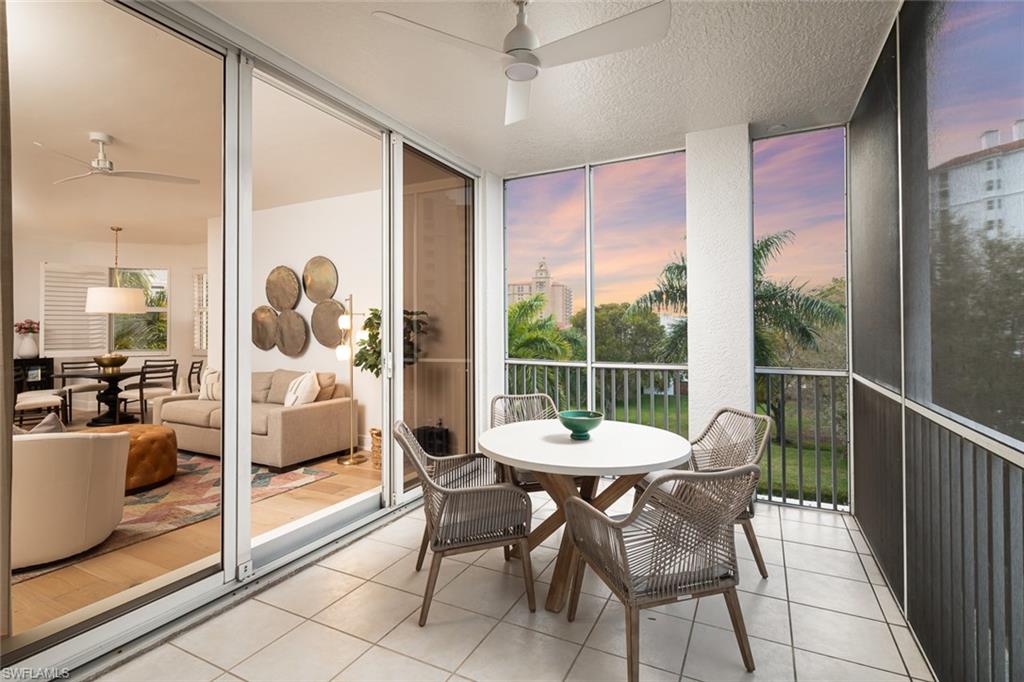 470 Launch Circle, Unit V401 Naples, FL 34108 - Photo 2 of 32 a view of a dining room and furniture wooden floor and a floor to ceiling window