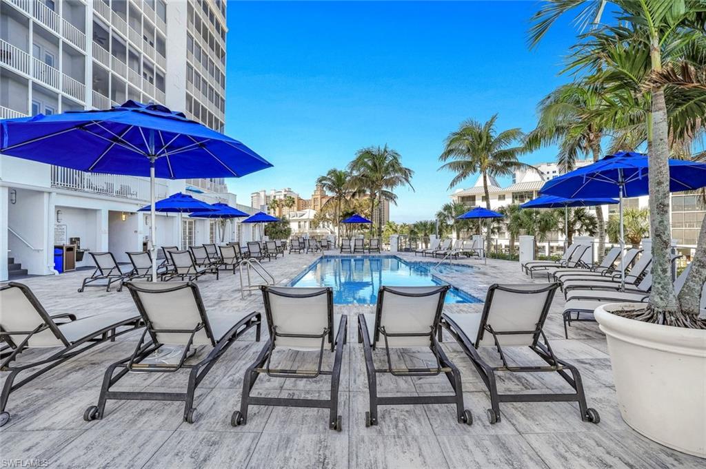 470 Launch Circle, Unit V401 Naples, FL 34108 - Photo 25 of 32 a view of patio with chairs and table under an umbrella
