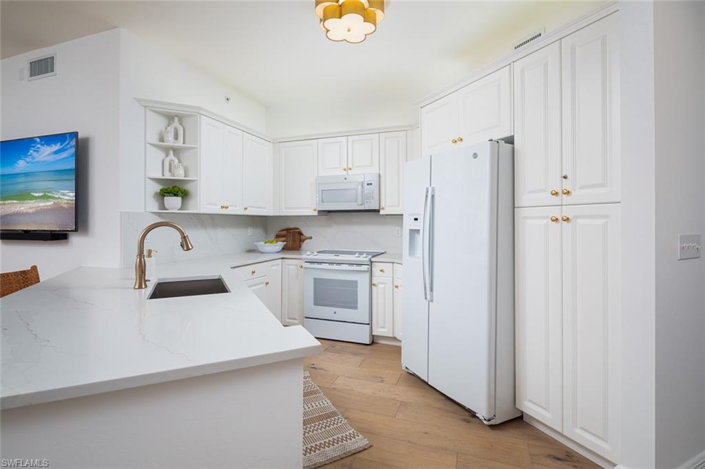 470 Launch Circle, Unit V401 Naples, FL 34108 - Photo 7 of 32 a kitchen with stainless steel appliances white cabinets and a refrigerator