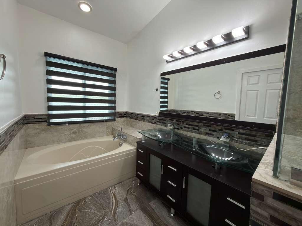 4572 Southwest 14th Street Deerfield Beach, FL 33442 - Photo 33 of 81 a bathroom with a granite countertop sink a toilet and bathtub