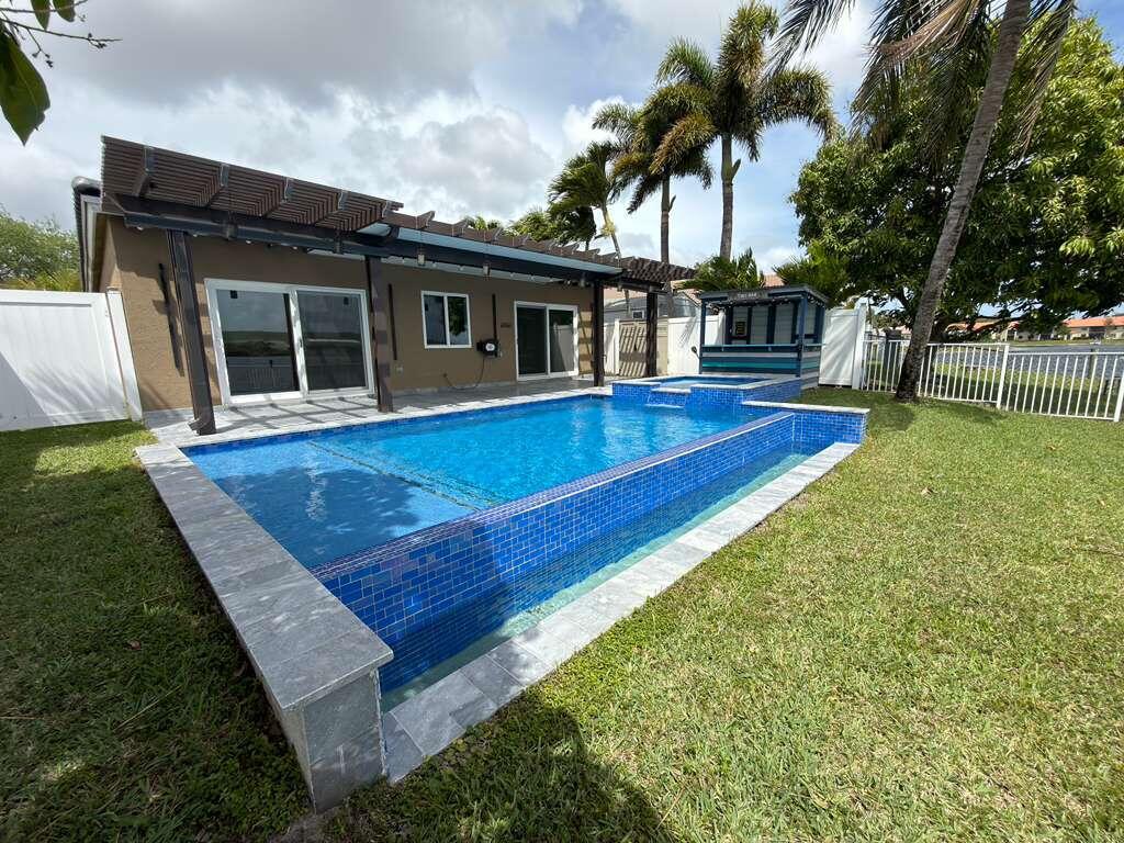 4572 Southwest 14th Street Deerfield Beach, FL 33442 - Photo 67 of 81 a view of a house with pool and a yard