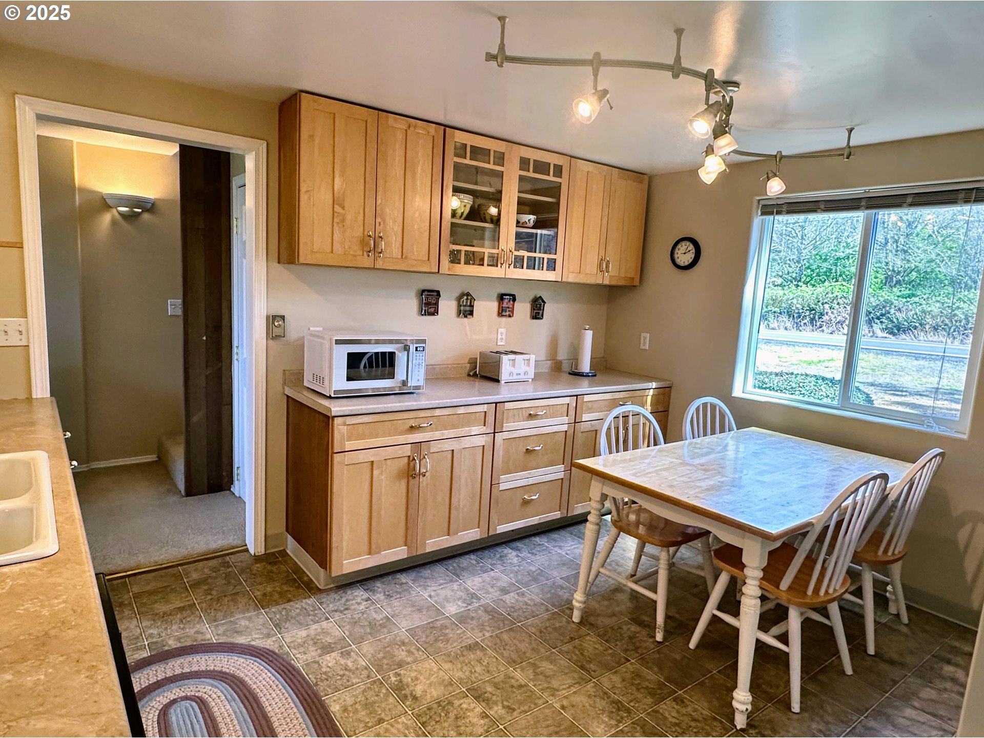 26230 Sandlake Road Cloverdale, OR 97112 - Photo 12 of 44 a kitchen with a stove a sink dishwasher a dining table and chair with wooden floor
