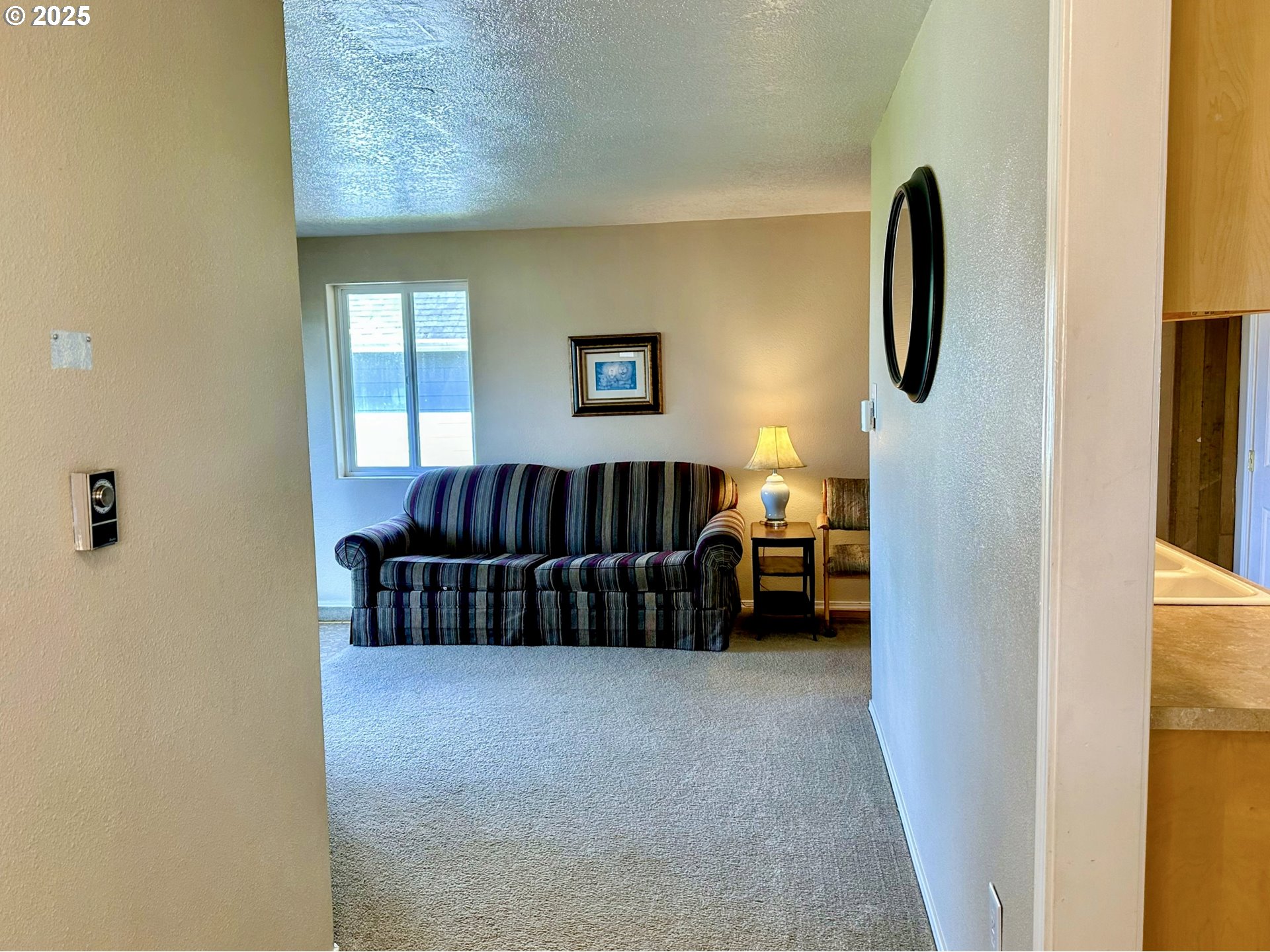 26230 Sandlake Road Cloverdale, OR 97112 - Photo 5 of 44 a living room with a couch and a dresser next to a window