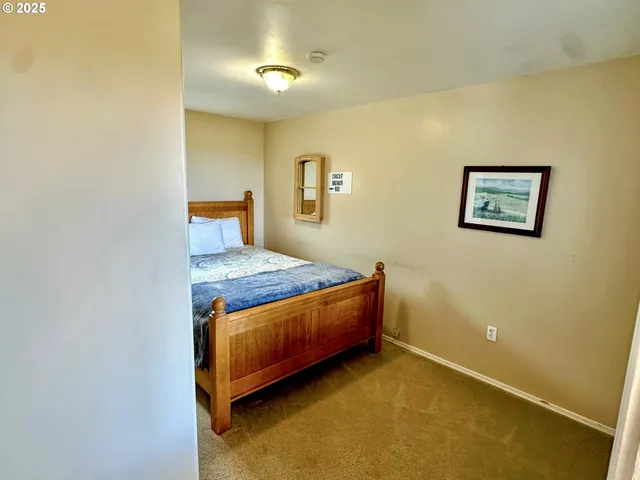 a living room with a bed and paintings on the wall