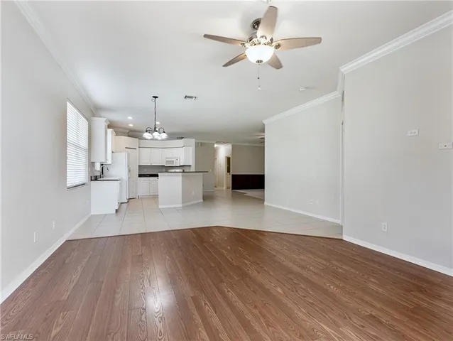 a view of a room with wooden floor and ceiling fan