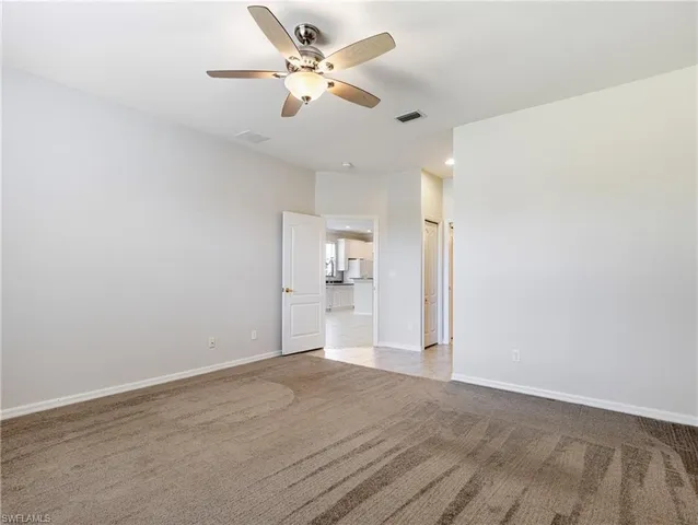 a view of a big room with wooden floor and a chandelier fan